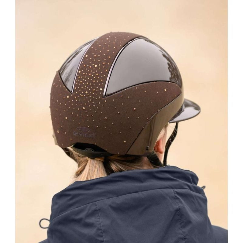 Profil latéral de femme souriante portant le casque d'équitation SWING H24 Lady Spark pailleté marro